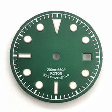 Green and white vintage-style diving watch dial with baton and dot markers.